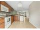 Kitchen features wood cabinets, white appliances, and a view into the living area at 3651 N Goldenrod Rd # B107, Winter Park, FL 32792