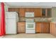 Modern kitchen with wood cabinets and white appliances at 3651 N Goldenrod Rd # B107, Winter Park, FL 32792