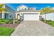 Two story home with a white garage door and a brick paved driveway at 1870 Summer Dr, Davenport, FL 33897