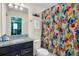 Bathroom with granite countertop, shower, and colorful floral shower curtain at 1870 Summer Dr, Davenport, FL 33897