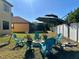 Relaxing backyard with firepit, patio furniture, and shade umbrella at 3044 Camino Real S Dr, Kissimmee, FL 34744