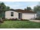One-story home with attached garage, landscaping, and a neutral color scheme at 1725 Forest Run Ln, Auburndale, FL 33823
