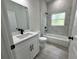 Modern bathroom with white vanity, bathtub, and gray tile flooring at 15096 Sw 51St Ave, Ocala, FL 34473