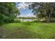 Scenic lake view from backyard, featuring lush vegetation and large trees at 3355 Scarlet Dr, Sanford, FL 32773