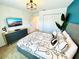 Spacious bedroom with a comfortable bed, dresser and large TV at 962 Splash Shot Pl, Davenport, FL 33896