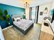Modern bedroom with a teal accent wall and comfortable bedding at 962 Splash Shot Pl, Davenport, FL 33896