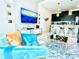 Bright and airy living room with open concept to kitchen, featuring comfortable seating and a large TV at 962 Splash Shot Pl, Davenport, FL 33896