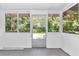 Empty screened porch with white walls and wood floors at 448 Nw 18Th Ave, Ocala, FL 34475