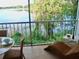 Serene lakefront view from a screened balcony with lounge chair at 4146 Versailles Dr # 4146D, Orlando, FL 32808