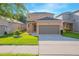Two-story house with brown garage door and landscaping at 1146 Atlantic Ave, Fruitland Park, FL 34731