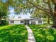 White ranch home with grey shutters and a nicely landscaped yard at 2502 Chanute Trl, Maitland, FL 32751