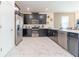 Modern kitchen with dark cabinetry, stainless steel appliances, and white tile floors at 4562 Narrative Ln, Kissimmee, FL 34746
