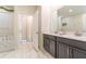 Double vanity bathroom with dark grey cabinets and marble tile floors at 4562 Narrative Ln, Kissimmee, FL 34746