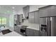 Modern kitchen with stainless steel appliances and gray cabinets at 555 Sanctuary Golf Pl, Apopka, FL 32712