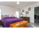 Main bedroom with purple comforter, blue bedskirt and wooden storage chest at 550 Saint Johns Rd, Tavares, FL 32778