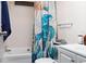 Bathroom with a shower/tub combo, white vanity, and a sea-themed shower curtain at 550 Saint Johns Rd, Tavares, FL 32778