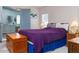 Main bedroom with purple comforter, blue bedskirt and wooden storage chest at 550 Saint Johns Rd, Tavares, FL 32778