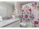 Clean bathroom with shower/tub combo, vanity, and patterned shower curtain at 8903 Stinger Dr, Davenport, FL 33896