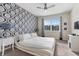 Serene bedroom with white bed, blue damask wallpaper, and window view at 8903 Stinger Dr, Davenport, FL 33896