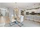 Elegant dining area with a glass table and modern white chairs, adjacent to kitchen at 8903 Stinger Dr, Davenport, FL 33896