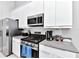 Modern kitchen with stainless steel appliances and gray countertops at 7740 Sandy Ridge Dr # 234, Reunion, FL 34747