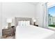 Bright bedroom with a queen-size bed, nightstands, and large window at 7740 Sandy Ridge Dr # 234, Reunion, FL 34747