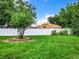 Large backyard with green grass, a tree, and a white vinyl fence at 428 Short Pine Cir, Orlando, FL 32807