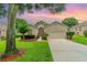 One-story house with beige exterior, mature landscaping, and a two-car garage at 3734 Hasting Ln, Clermont, FL 34711