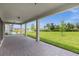 Spacious covered patio overlooking a lush green lawn and lake at 13839 Larkton Ln, Orlando, FL 32832