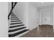 Modern staircase with black and white risers and dark wood railing at 13839 Larkton Ln, Orlando, FL 32832
