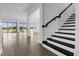 Modern staircase with black and white risers and dark wood railing at 13839 Larkton Ln, Orlando, FL 32832