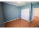 Spacious bedroom featuring wood-look floors and double doors to closet at 4028 Navigator Way, Kissimmee, FL 34746