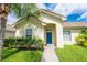 One-story home with blue door and lush landscaping at 4028 Navigator Way, Kissimmee, FL 34746