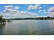 Scenic view of a lake with a dock, lush trees, and a partly cloudy sky at 437 Oak Haven Dr # 437, Altamonte Springs, FL 32701