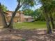 View of the house and yard from behind mature trees at 9525 Mcnorton Rd, Altamonte Springs, FL 32714
