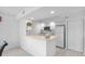 Efficient galley kitchen features white cabinetry, built-in microwave, and breakfast bar at 1150 Carmel Cir # 408, Casselberry, FL 32707