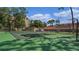 Alt text: Green tennis court with basketball hoop and building in background at 1150 Carmel Cir # 408, Casselberry, FL 32707