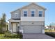 Two-story house with gray siding, two-car garage, and landscaping at 27512 Stellar Sea Way, Howey In The Hills, FL 34737