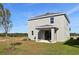 Rear view of two-story house with covered patio and grassy yard at 27512 Stellar Sea Way, Howey In The Hills, FL 34737