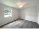 Bright bedroom with gray carpeting and a window offering natural light at 3235 Cross Fox Dr, Mulberry, FL 33860