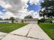 House exterior featuring a beige color, a two-car garage, and a well-maintained lawn at 3235 Cross Fox Dr, Mulberry, FL 33860