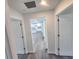 Bright hallway with light grey vinyl flooring and doors leading to bedrooms and kitchen at 2220 Church St, Sanford, FL 32771