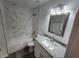 Bathroom with marble-style tile, granite countertop vanity, and bathtub at 2220 Church St, Sanford, FL 32771