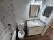 Clean bathroom with marble-look tile, granite countertop, and a white vanity at 2220 Church St, Sanford, FL 32771