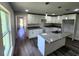 Kitchen with island, granite countertops, white cabinets, and vinyl plank flooring at 2220 Church St, Sanford, FL 32771