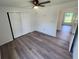 Bedroom with grey vinyl flooring, ceiling fan, and sliding closet doors at 2220 Church St, Sanford, FL 32771