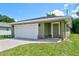 House exterior featuring a one-car garage, green exterior, and a landscaped yard at 2261 Greenway St, Sanford, FL 32771