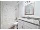 Bathroom with granite countertop, white cabinets, and marble-style shower/tub combo at 2261 Greenway St, Sanford, FL 32771