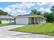 House exterior featuring a one-car garage, green exterior, and a landscaped yard at 2261 Greenway St, Sanford, FL 32771