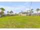 Expansive grassy backyard, surrounded by a fence and palm trees at 1232 Bel Aire Dr, Daytona Beach, FL 32118